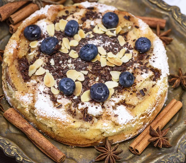 baked round cake with blueberries on an iron plate, cake sponge
