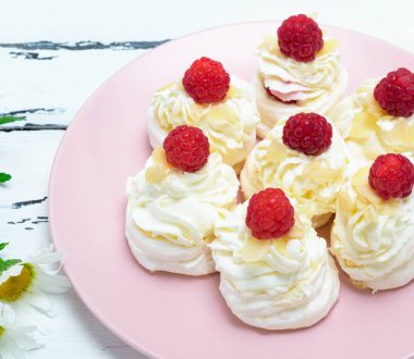 kek yapılan yumurta beyaz ve pembe bir tabağa ahududu ile beyaz krem şanti