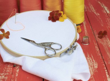 beyaz kumaş ve ahşap bir masa üzerinde nakış iş parçacığı ile ahşap hoop yakın çekim