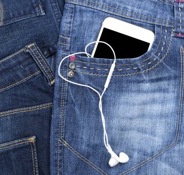 boş bir siyah ekran ve kulaklık ile beyaz smartphone açık mavi kot pantolon cebinde yalan, yakın çekim