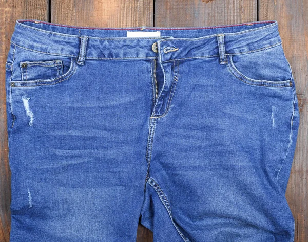 Jeans Clássico Azul Com Arranhões Fundo Madeira Marrom Vista Superior — Fotografia de Stock