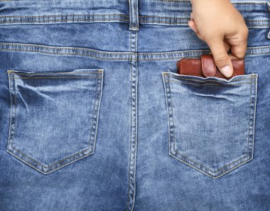 insan eli kot arka cebinden bir kahverengi deri çanta, çalmak kavramı çeker.