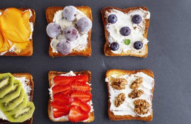 Fransız tost yumuşak peynir, çilek, kivi, ceviz ve yaban mersini siyah tahtasında, üstten görünüm
