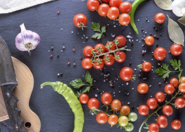 Olgun kırmızı kiraz domates, biber ve baharat siyah bir arka plan üzerinde Kapat