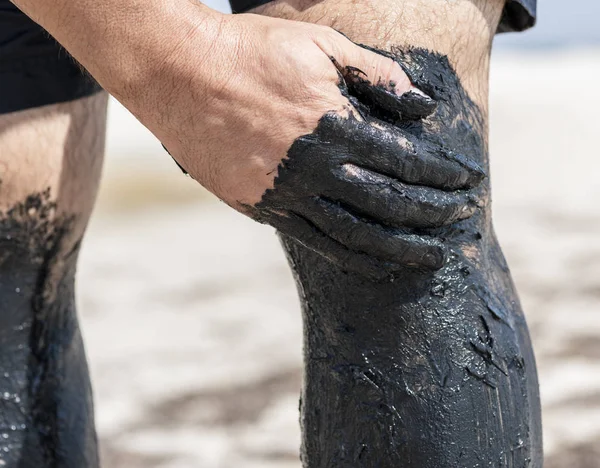 Man Hand Smears Leg Black Mud Treatment Natural Components Joints — Stock Photo, Image