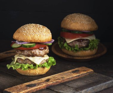 büyük burger iki kızarmış pirzola, peynir ve yuvarlak buğday unu çörek sebze