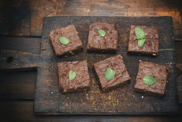 brownie kek pasta bir eski kahverengi ahşap kesme tahtası, üstten görünüm üzerinde kare adet pişmiş