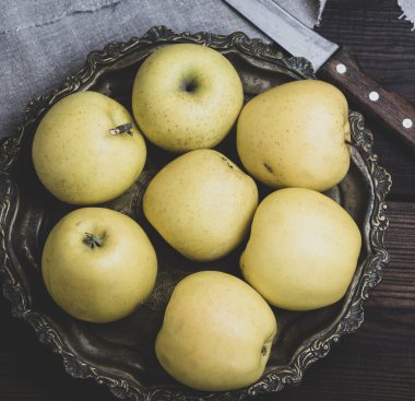 Olgun bütün sarı elma bir demir plaka, üstten görünüm, vintage tonlama