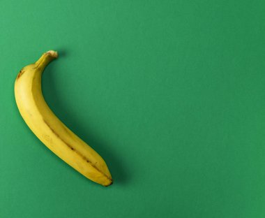 olgun sarı bir muz üzerinde yeşil bir arka plan kopya alanı
