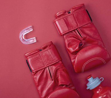 Kırmızı boks spor eldivenleri, silikon ağızlık kırmızı bir arka plan üzerinde diş için en iyi görünümü
