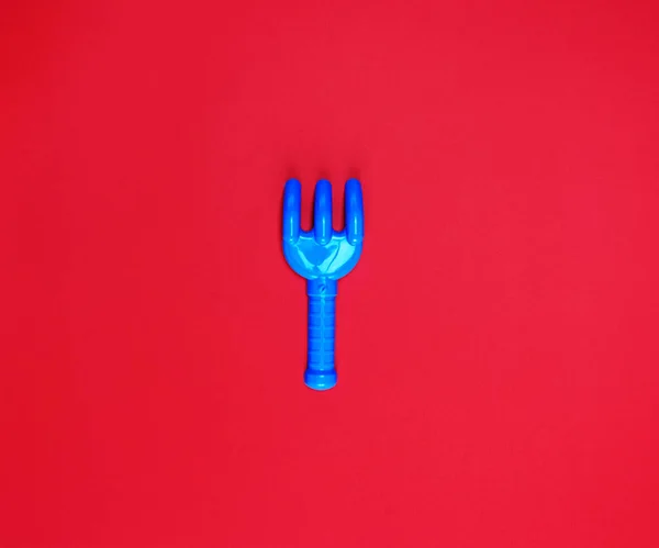 Blue Plastic Baby Rake Red Background Empty Space — Stock Photo, Image