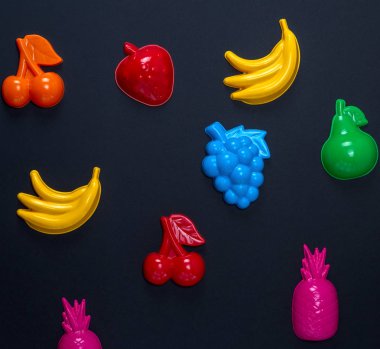 çok renkli plastik oyuncaklar meyve siyah bir zemin üzerine yakın çekim