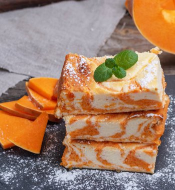 Siyah kesme tahtasında balkabağı olan kare parça cheesecake, üst manzara