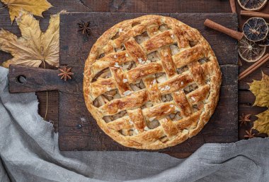 Bütün yuvarlak elmalı turta bir dikdörtgen eski kahverengi masa, ahşap masa, üstten görünüm üzerinde pişmiş
