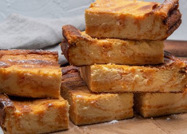 Kahverengi kâğıt üzerinde süzme peynir ve balkabağı gibi dikdörtgen bir pastanın parçalarını kes.