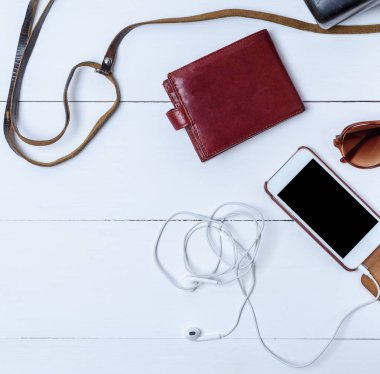 Beyaz smartphone ile beyaz ahşap zemin üzerine boş siyah perde, kahverengi deri cüzdan