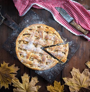 Bütün yuvarlak elmalı turta bir dikdörtgen eski kahverengi masa, ahşap masa, üstten görünüm üzerinde pişmiş
