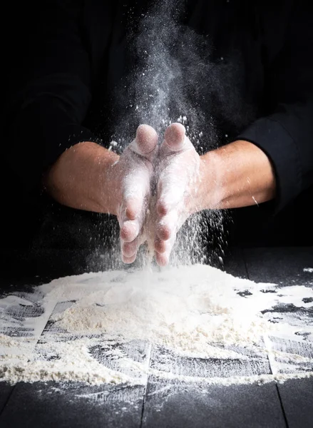 Mãos Homem Salpico Farinha Trigo Branco Fundo Preto — Fotografia de Stock