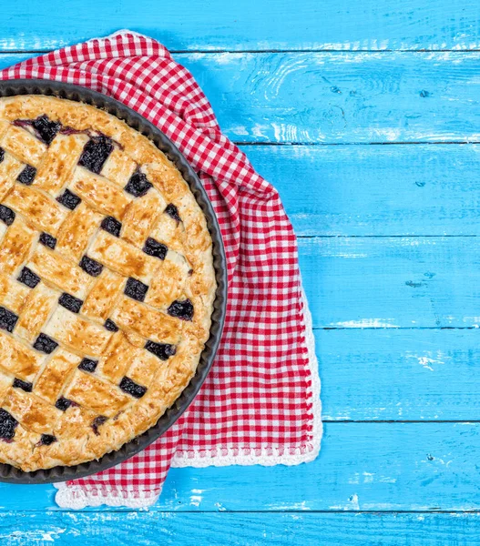 half of fruit pie on blue wooden background, copy space