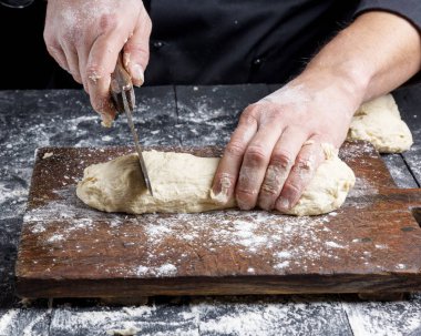 Şef kesim beyaz buğday unu hamur bir eski vintage bıçakla parçalara yakın çekim