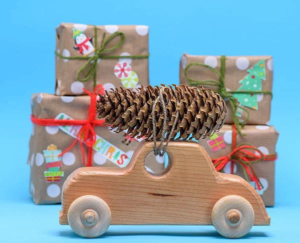 wooden machine carries a rope tied cone against a background of wrapped gifts, Christmas celebratory background