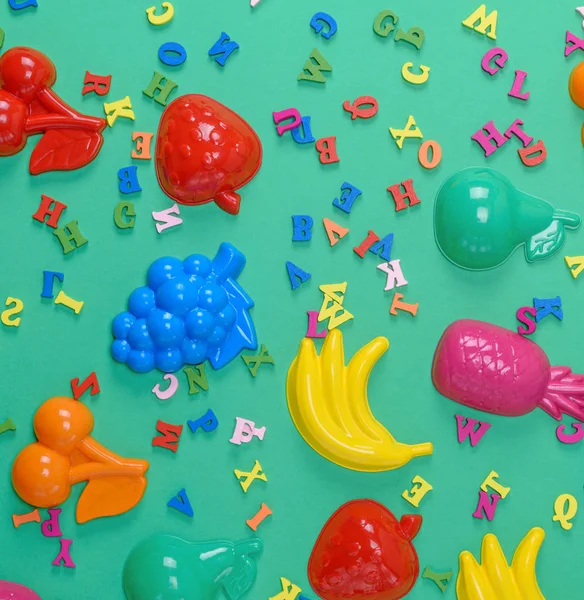 Groene Achtergrond Met Childrens Plastic Speelgoed Houten Veelkleurige Letters Bovenaanzicht — Stockfoto