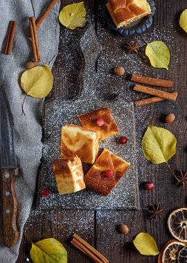 süzme peynir ve kabak pasta tatlı bir ahşap tahtada kare parçalar ile krema şeker, üstten görünüm tozunu
