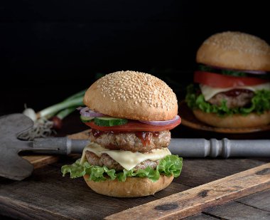  İki kızarmış pirzola, peynir ve yuvarlak buğday unu çörek Sebze Burger