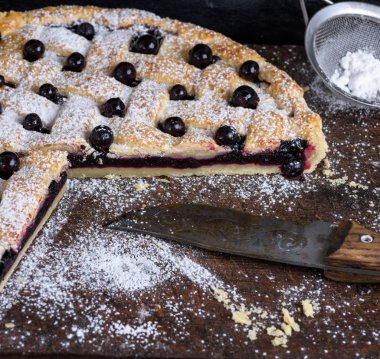 ahşap arka plan üzerinde yuvarlak siyah frenk üzümü pasta, yakın çekim