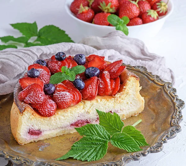 Cheesecake bir bakır yuvarlak tabakta olgun taze çilek ile yakın çekim