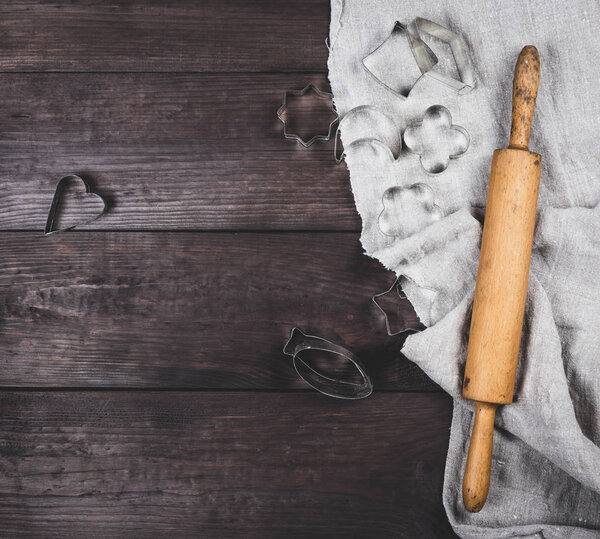 wooden rolling pin and iron bakeware on a brown wooden table, copy space