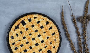 yuvarlak siyah frenk üzümü pasta üzerinde gri arka plan, üstten görünüm