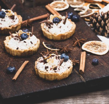 bir kahverengi ahşap tahta üzerinde beyaz krema ve Çikolata tozu ile tatlı kek