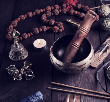 Bakır şarkı kasesi, dua boncukları ve diğer Tibet dini objeleri meditasyon ve alternatif tıp için ahşap arka planda.