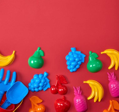 meyve ve kırmızı bir arka plan üzerine bir kova şeklinde Plastik çocuk oyuncakları
