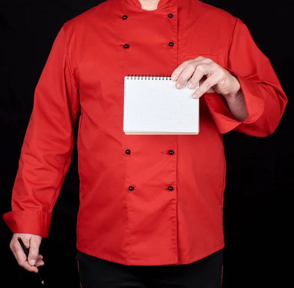 Chef Uniforme Vermelho Segurando Caderno Papel Branco Fundo Preto Espaço — Fotografia de Stock