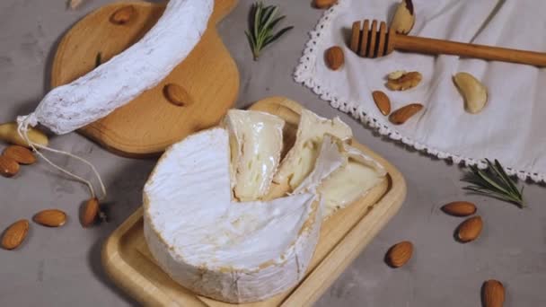 Pedaço Redondo Queijo Brie Salsicha Uma Placa Madeira Fundo Cinza — Vídeo de Stock