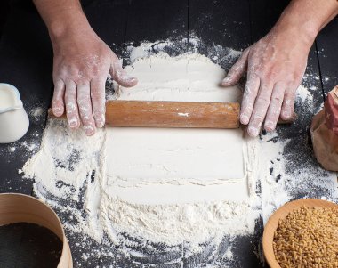 ahşap oklava erkek elinde sonraki beyaz buğday unu dağınık