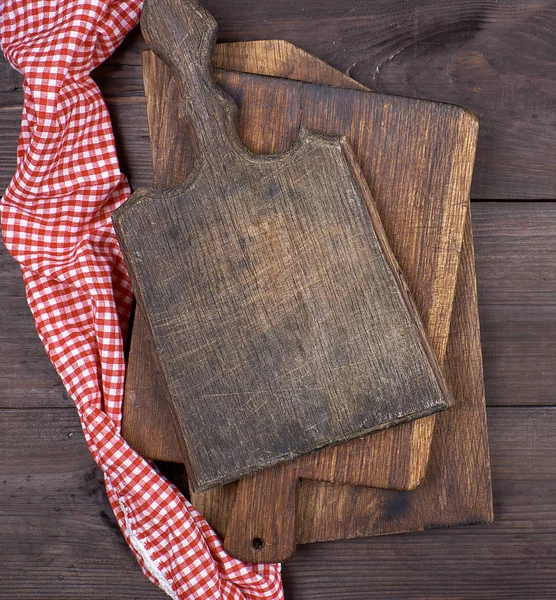 old wooden kitchen chopping boards and a red towel on a brown table, the view from the top