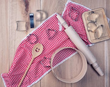 boş yuvarlak ahşap elek ve merdane kırmızı tekstil mutfak havlusunda, kurabiye için demir formların yanında