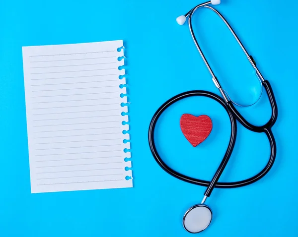 blank white piece of paper in a line and a medical stethoscope on a blue background