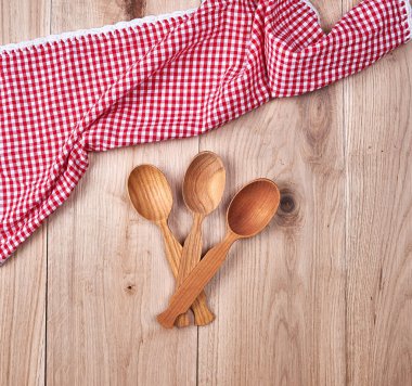 üç tahta kaşıklar üzerinde kırmızı mutfak havlu, kopya alanı boş