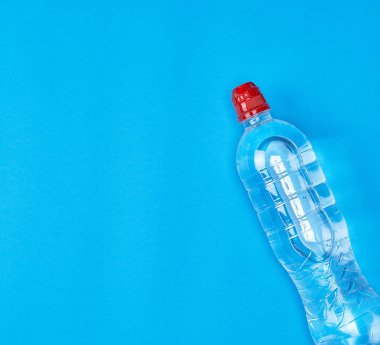 üzerinde mavi bir arka plan kopya alanı temiz su ile şeffaf plastik şişe
