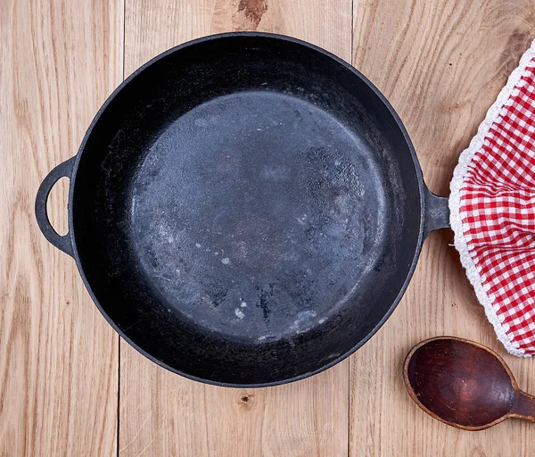 Frigideira Redonda Preta Vazia Guardanapo Cozinha Vermelho Uma Mesa Madeira — Fotografia de Stock