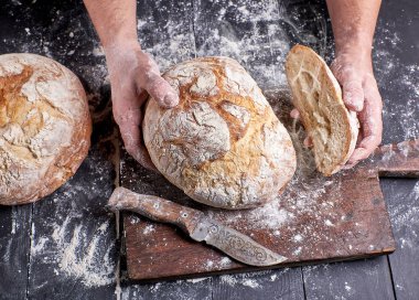 Şef sıcak taze tutan bir siyah üniformalı yuvarlak ekmek 