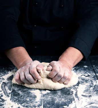 Şef siyah üniformalı beyaz buğday unu hamur kneads