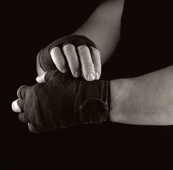 Man wraps his hands in black textile bandage for sports — Stock Photo, Image