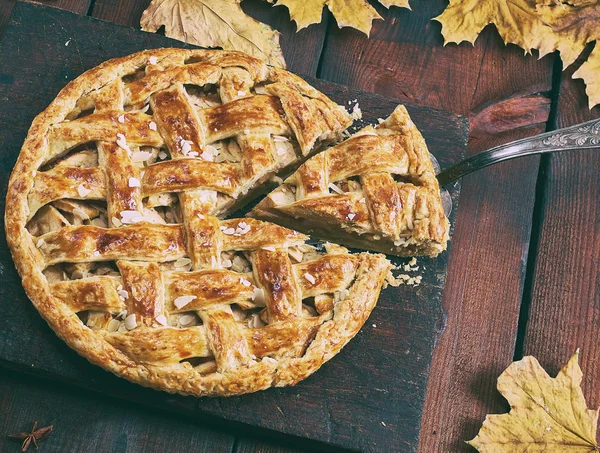 Torta de maçã redonda em uma tábua de madeira marrom, massa folhada — Fotografia de Stock