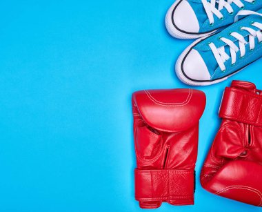 bir çift kırmızı boks eldivenleri ve mavi Tekstil spor ayakkabı