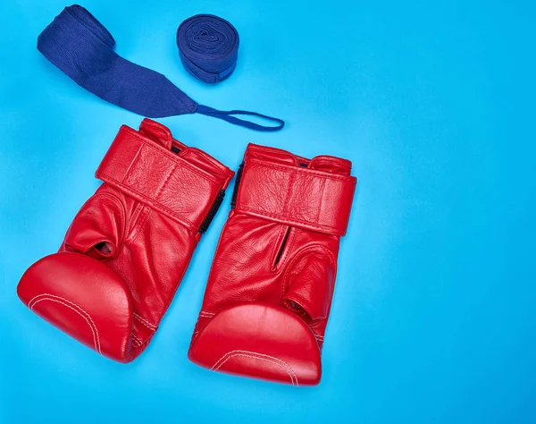 Un par de guantes de boxeo de cuero rojo y un vendaje textil —  Fotos de Stock